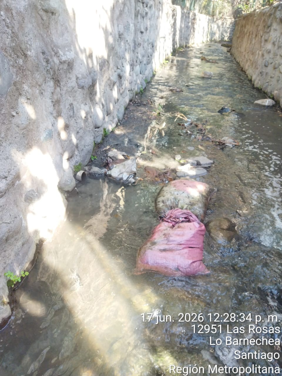 12951 Las Rosas — saco de desechos vertido en el canal